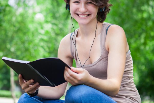 Nachhilfe-Schülerin lernt im Park mit einem Buch